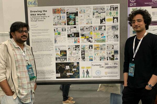 Saurja and Argha stand next to their comic book presentation.